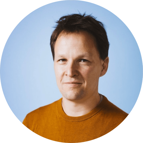 Man in an orange sweater with a light blue background